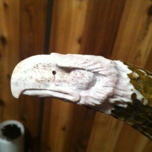 A wooden hand carved eagle head on the knife